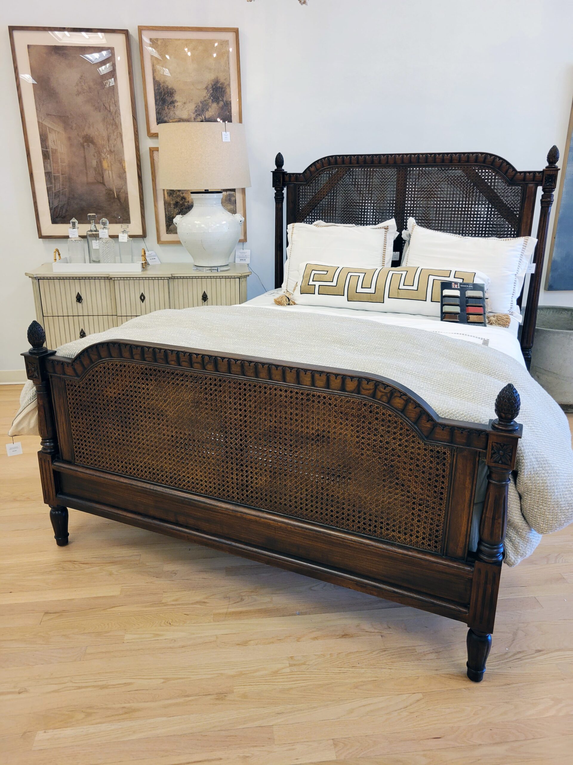 ornate bedframe with linens and nightstand