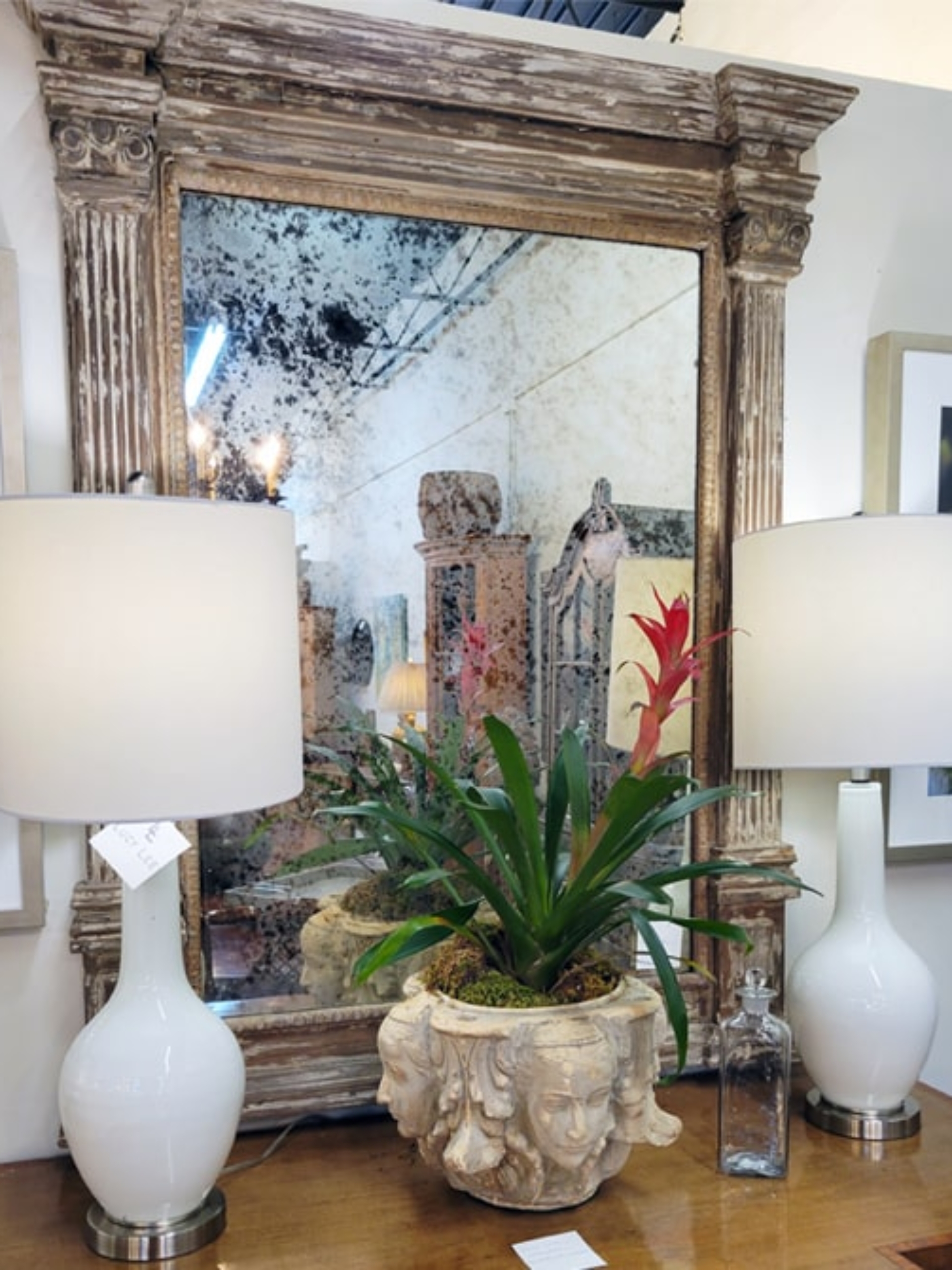 ornate distressed mirror with wooden frame and lamps